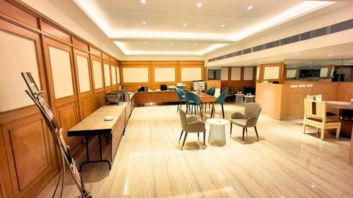 A spacious and well-lit lobby at Pride Plaza Ahmedabad, featuring comfortable seating arrangements, wooden flooring, and elegant decor.